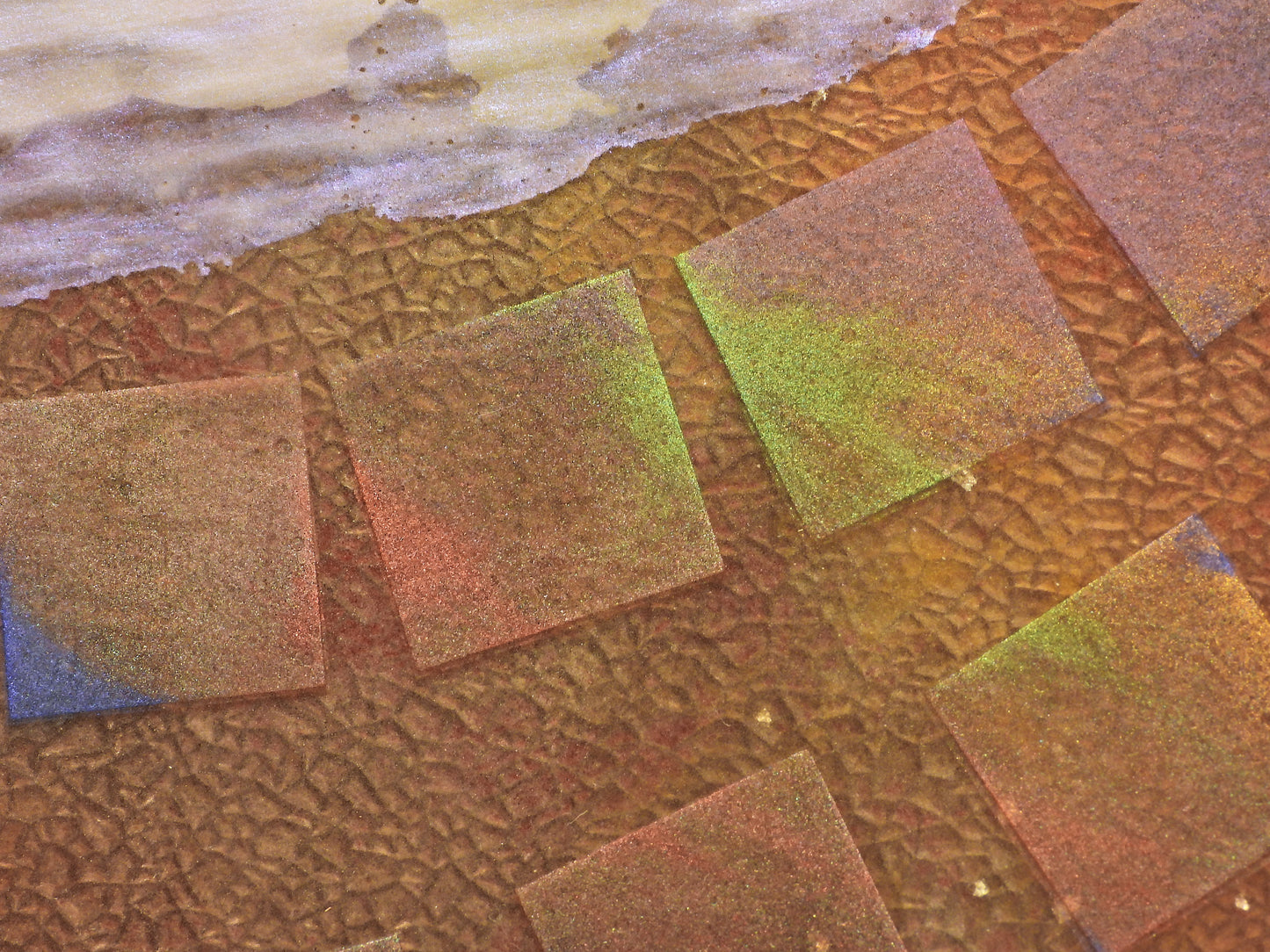 Close-up of textured square tiles in various colors on a textured surface.