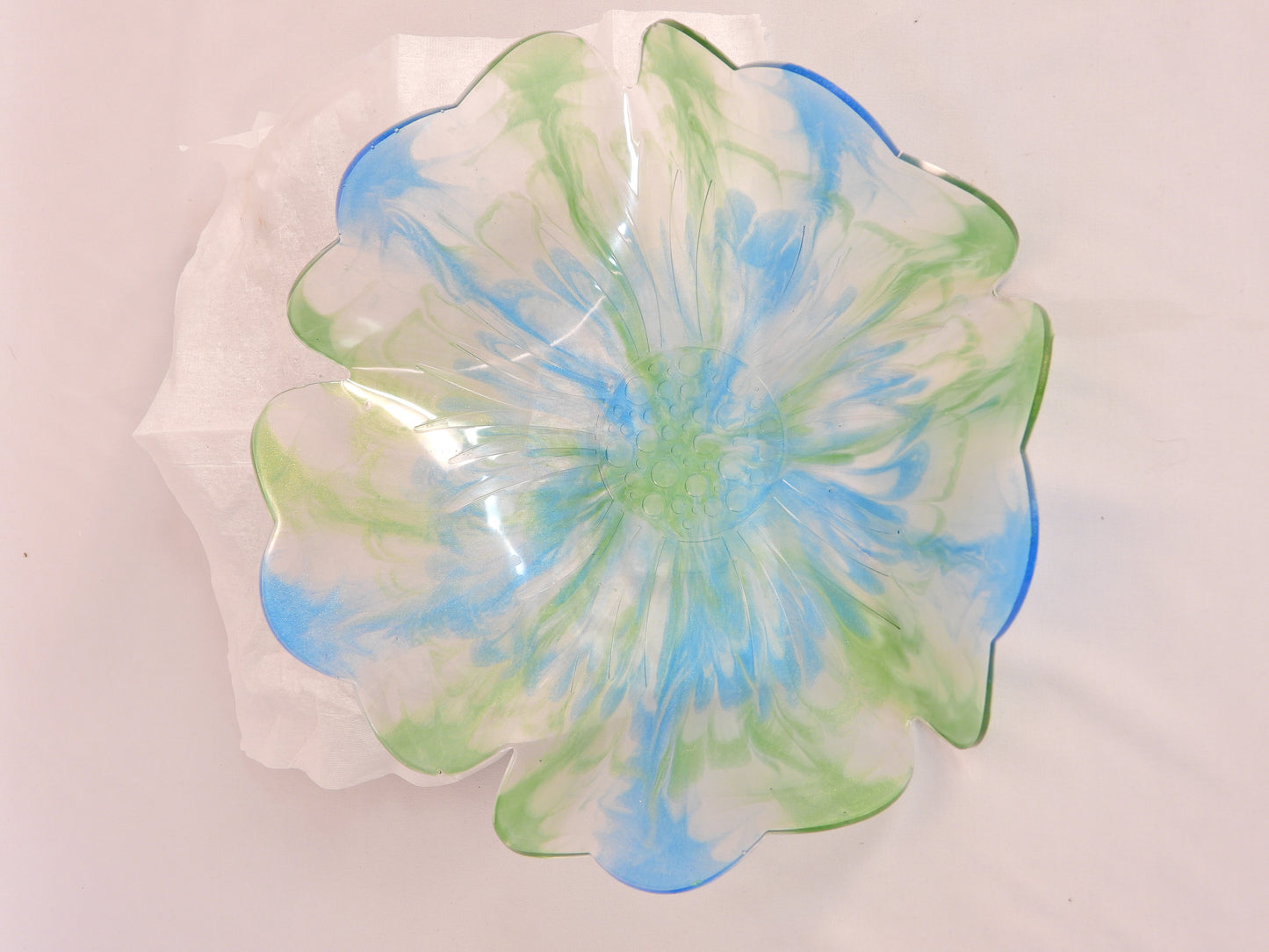 Decorative resin bowl with blue and green spiral design on a white background