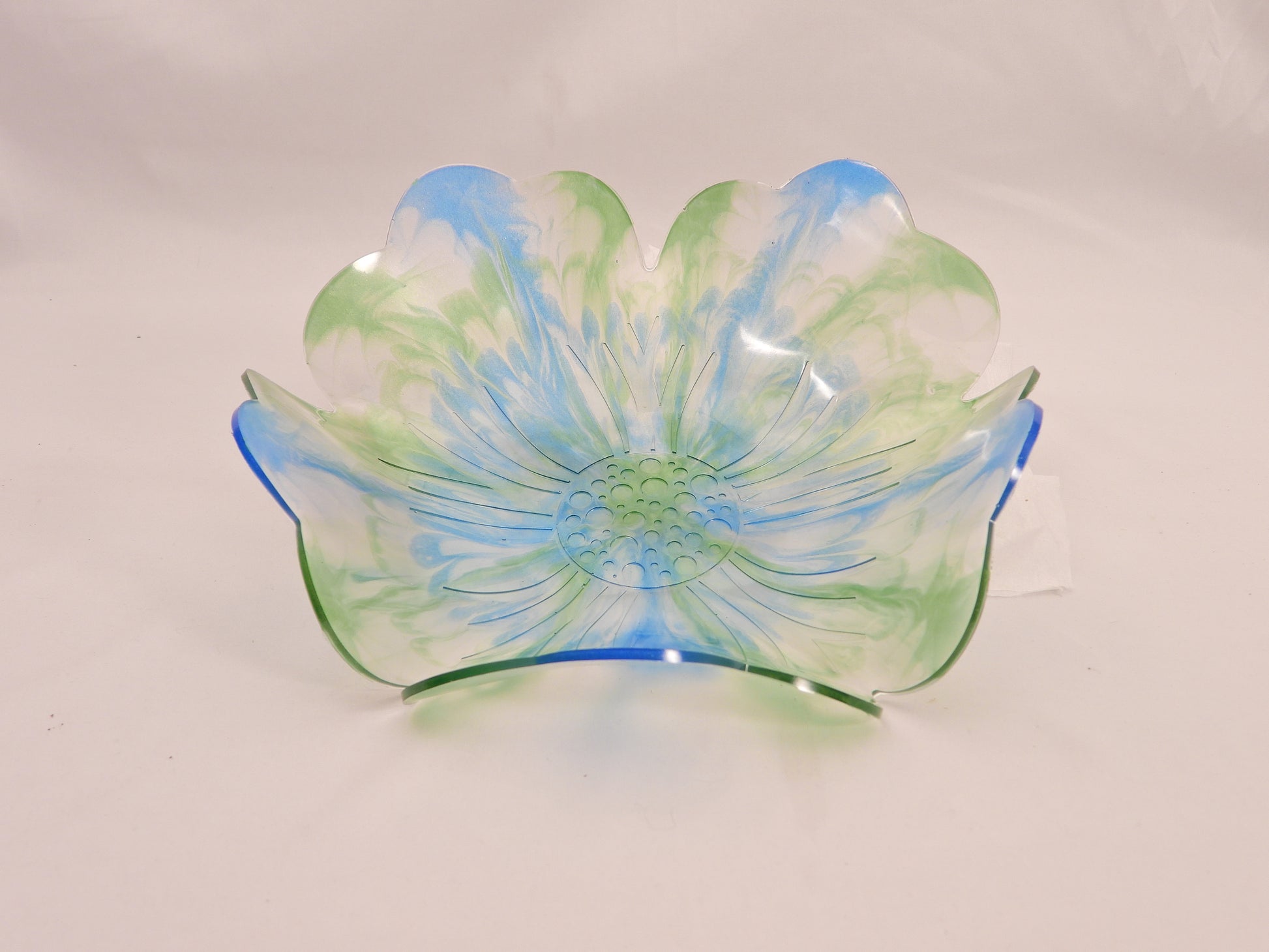 Decorative resin bowl with blue and green floral design on a white background