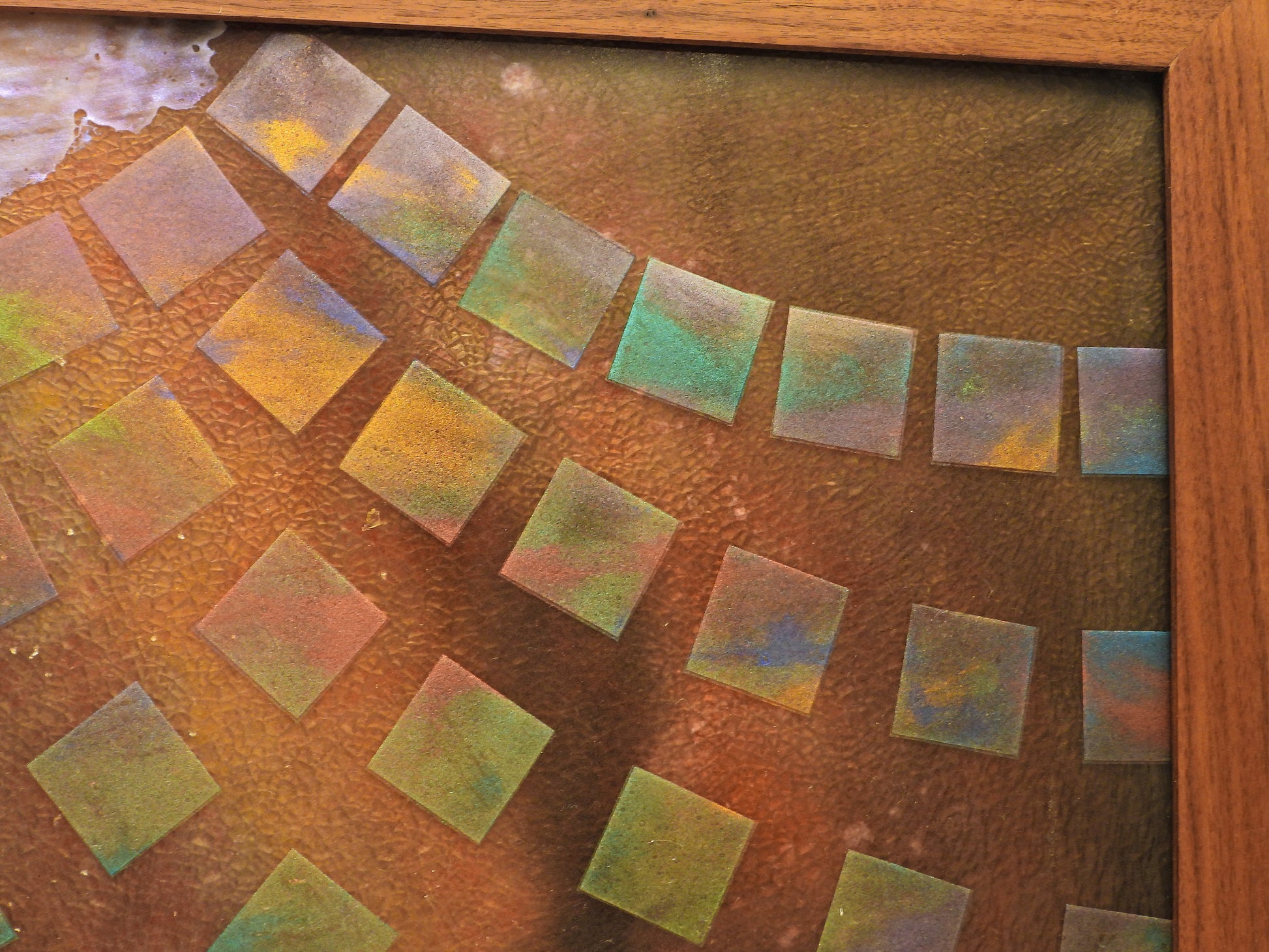 Colorful square tiles on a textured surface with a wooden frame